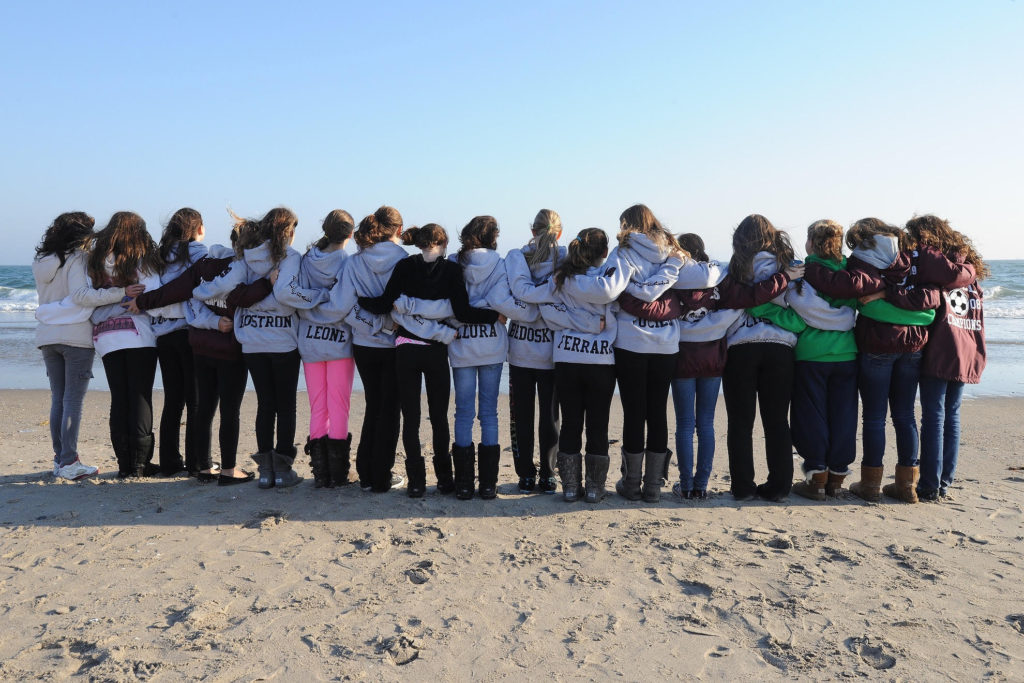 On Nov. 11,2012, A group of girls from St Mels School Soccer team in Flushing Queens stand on the beach in Rockaway Queens, in a quiet moment of reflection after coming to Rockaway with cleaning supplies for fellow students from St. Francis School, who they compete with on the soccer field. photo by Doug Kuntz