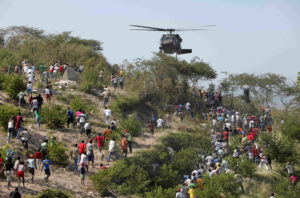 People run toward a U.S. helicopter as it makes a water drop near a country club used as a forward operating base for the U.S. 82nd Airborne Division in Port-au-Prince, Haiti, Saturday, Jan. 16, 2010. Relief groups and officials are focused on moving aid flowing into Haiti to survivors of the powerful earthquake that hit the country on Tuesday.  (AP Photo/Jae C. Hong) XJH106