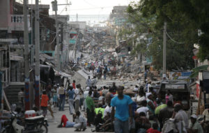 Local residents crowd a devastated street in Port-au-Prince, Haiti, on Wednesday, Jan. 13, 2010. Huge swaths of Port-au-Prince lay in ruins, and thousands of people were feared dead in the rubble of government buildings, foreign aid headquarters and shantytowns that collapsed a day earlier in a powerful earthquake. (Damon Winter/The New York Times)